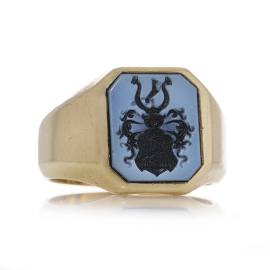 A yellow gold ring with an octagonal sardonyx intaglio, on a white background
