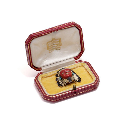 Cartier brooch in gold, silver and enamel set with gem.