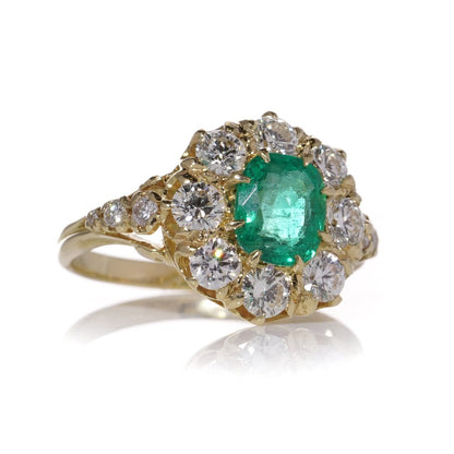Emerald and diamond cluster ring in gold.