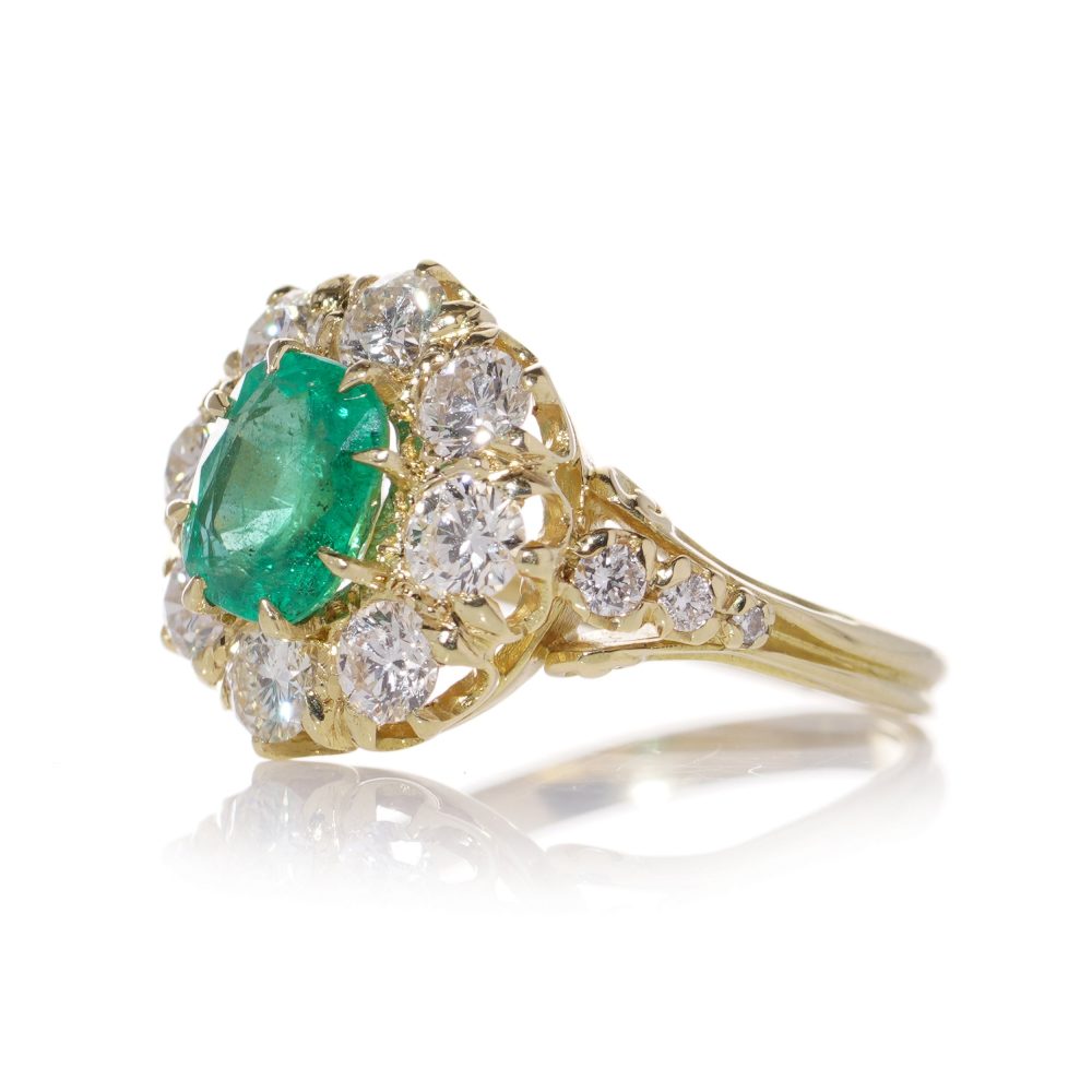 Emerald and diamond cluster ring in gold.