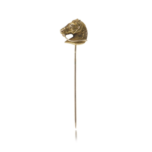 A yellow gold tie or stick pin featuring a horse's head, on a white background
