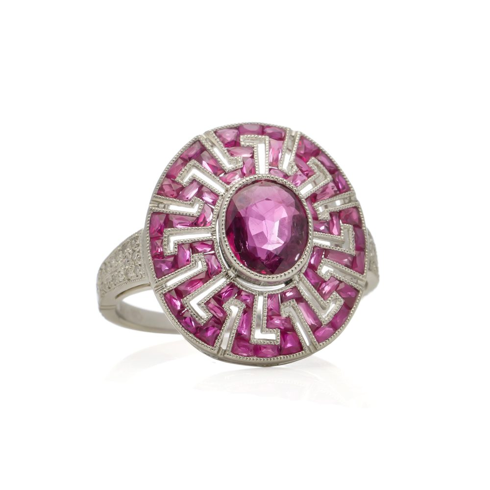 Platinum oval ruby cluster ring surrounded by rubies diamonds.