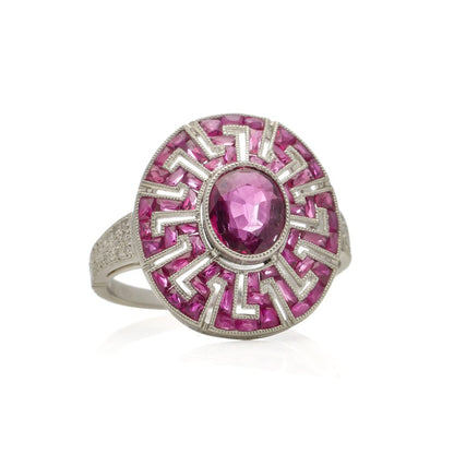 Platinum oval ruby cluster ring surrounded by rubies diamonds.