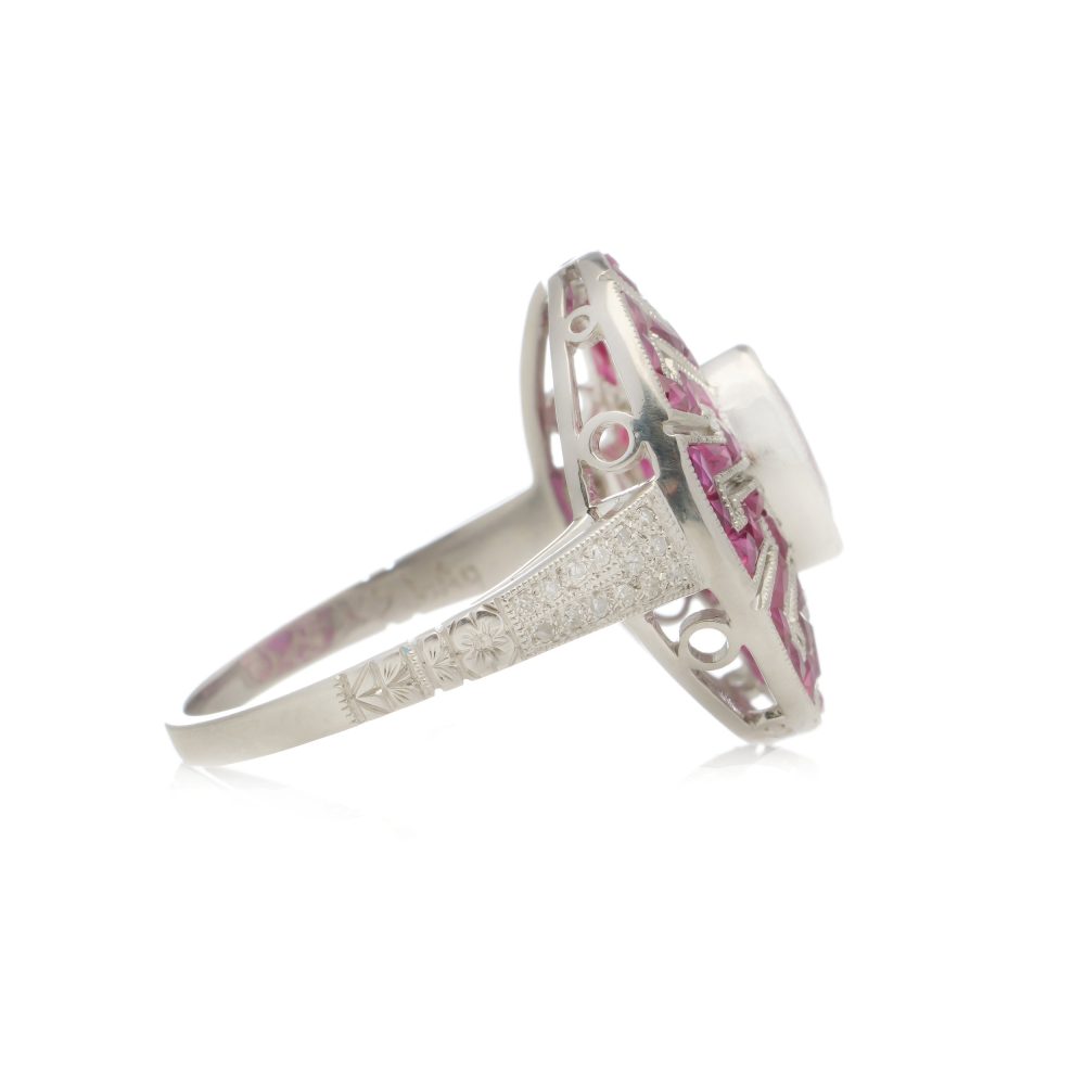 Platinum oval ruby cluster ring surrounded by rubies diamonds.