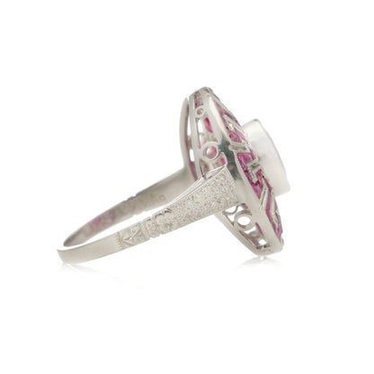 Platinum oval ruby cluster ring surrounded by rubies diamonds.