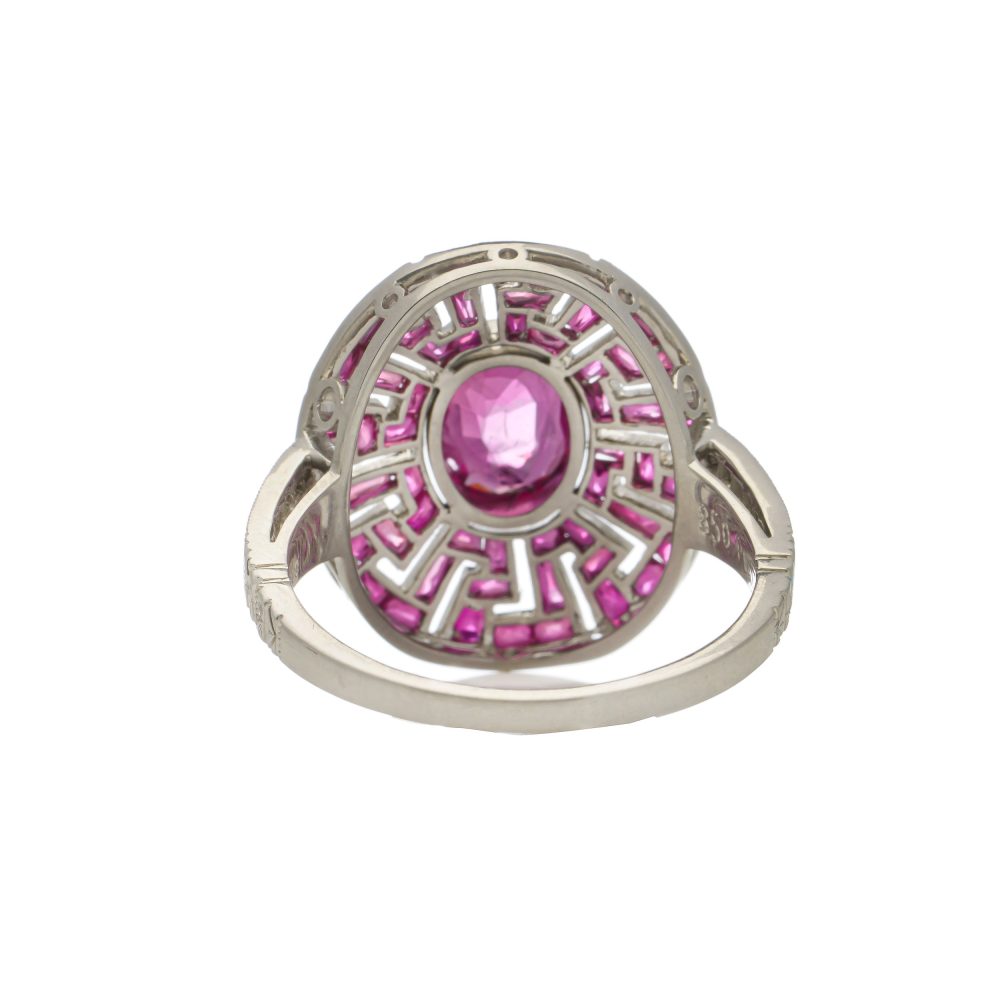 Platinum oval ruby cluster ring surrounded by rubies diamonds.