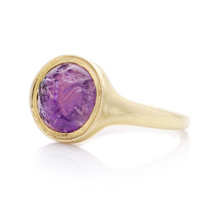 Roman carved intaglio amethyst ring featuring Eros riding a dolphin mounted in gold.
