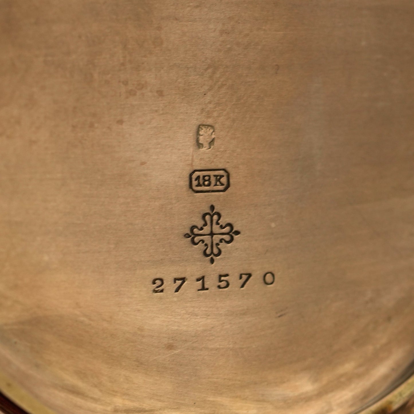 Close-up of a gold object with '18K' and number '271570' engraved on it