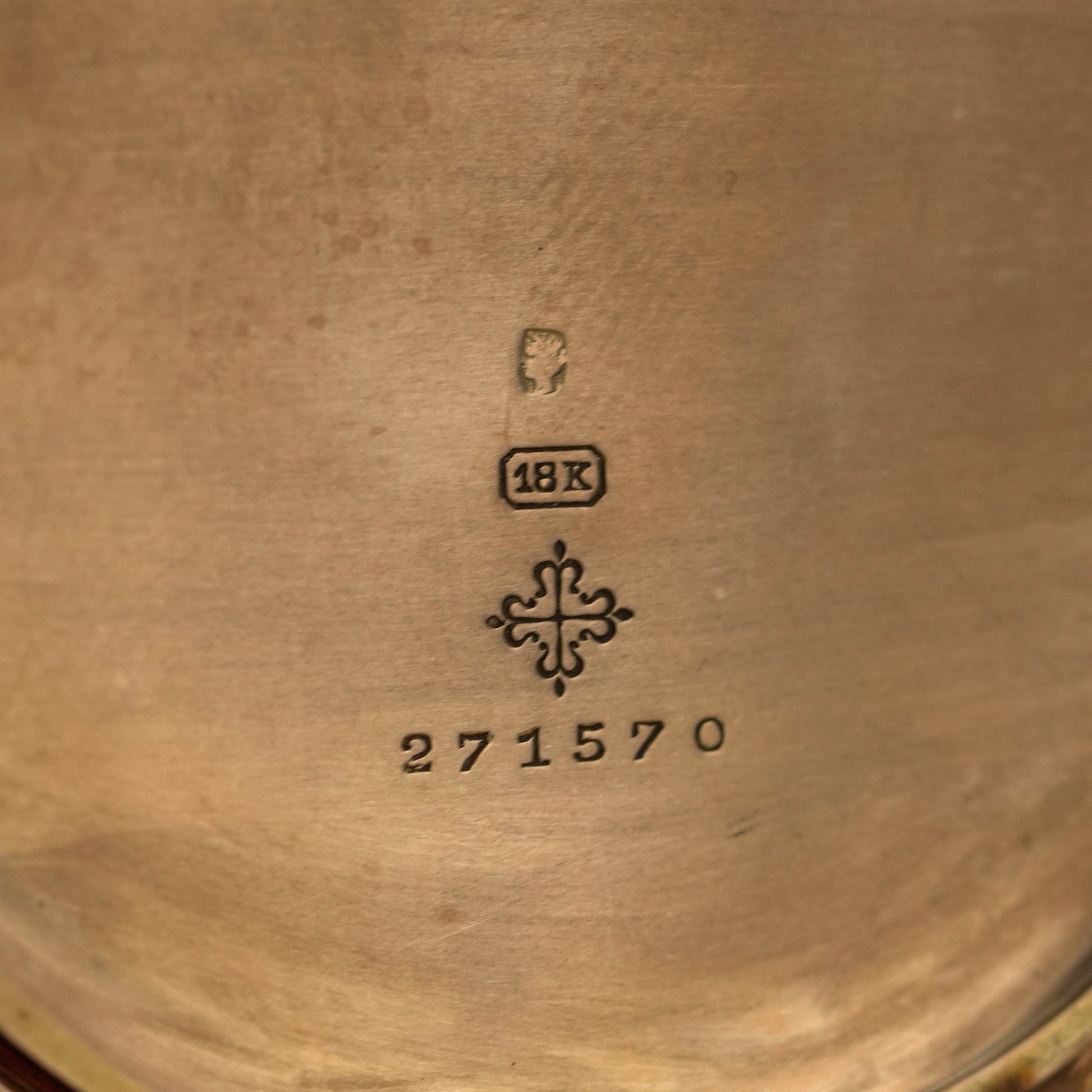 Close-up of a gold object with '18K' and number '271570' engraved on it