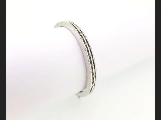 Diamond Bangle; Triple row of interspersed round cut diamonds set into an 18ct white gold bangle. A delicate and chic piece of jewellery