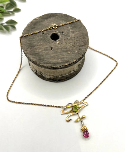 A yellow gold pendant necklace with pearls, a peridot, a diamond and a pink tourmaline drop