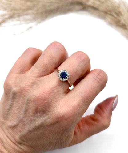A sapphire and diamond flower cluster ring in yellow gold and platinum, modelled on a hand