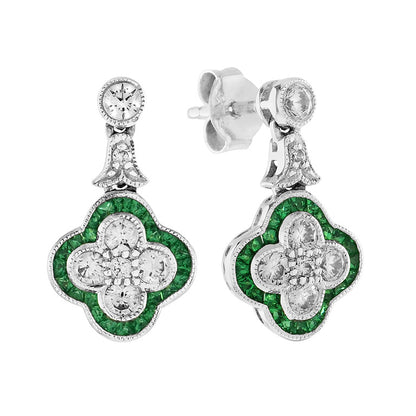 Diamond and Emerald Quatrefoil Cluster Drop Earrings; central diamond cluster surrounded by a border of French-cut emeralds in a quatrefoil design, suspended from a diamond set stud via a diamond-set fleur-de-lis link, in 18ct white gold