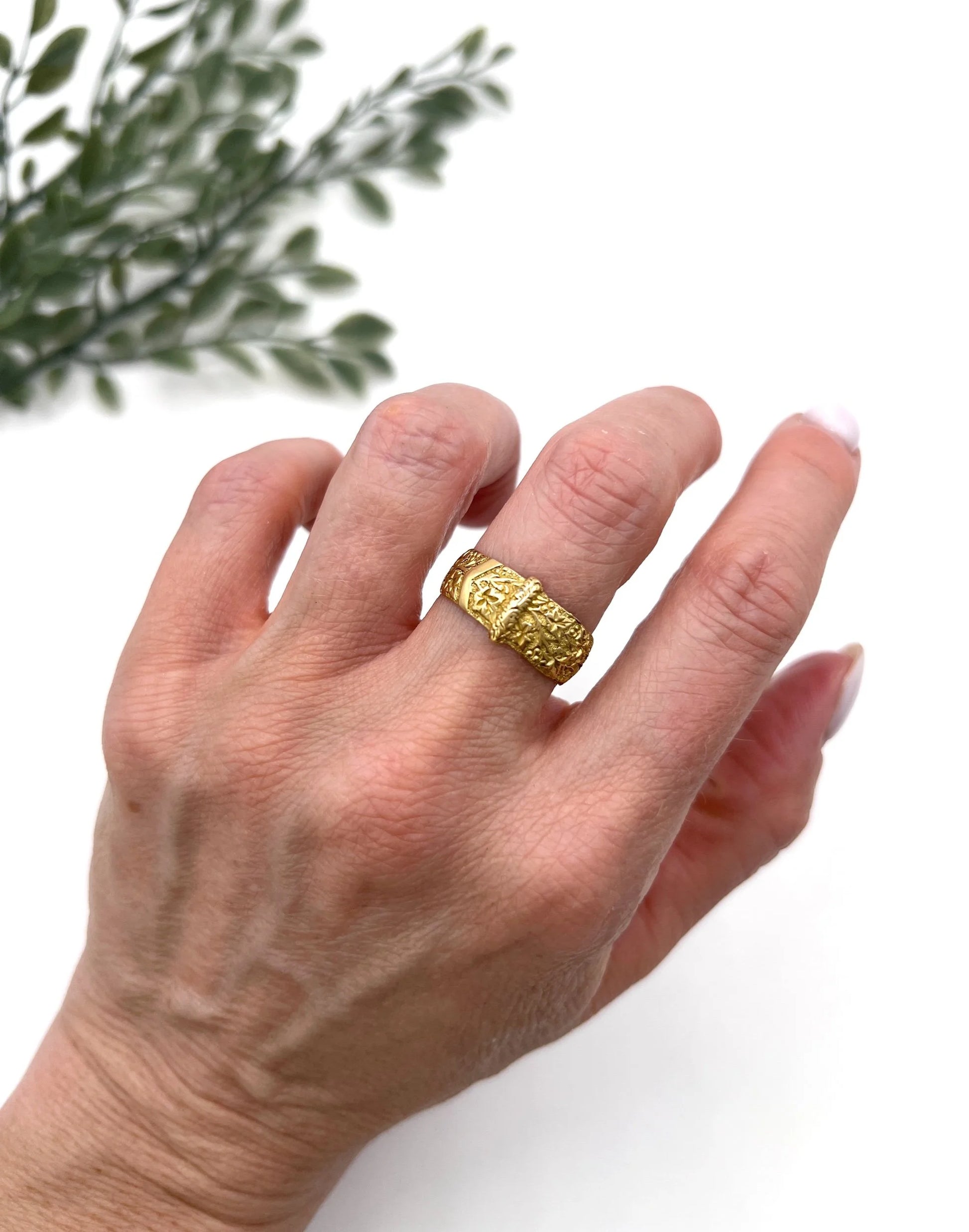 A yellow gold ornate engraved buckle band ring, modelled on a hand