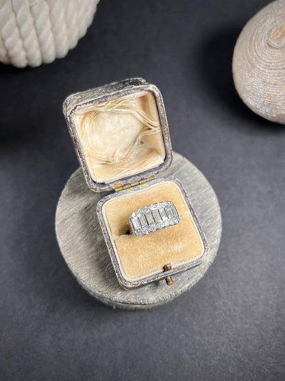 A three row diamond band ring in platinum in an antique ring box