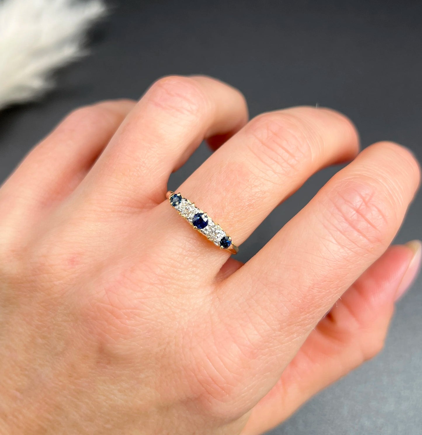 A yellow gold five stone sapphire and diamond carved half hoop ring, modelled on a hand