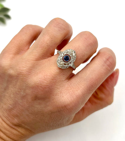 A sapphire and diamond openwork ring in platinum with a yellow gold ring shank, modelled on a hand