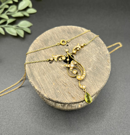 A yellow gold floral pendant necklace with pearls and a peridot drop