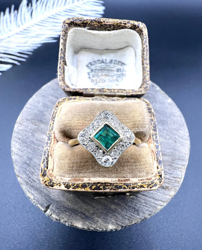 An emerald and diamond cluster ring in yellow gold and platinum, in an antique ring box