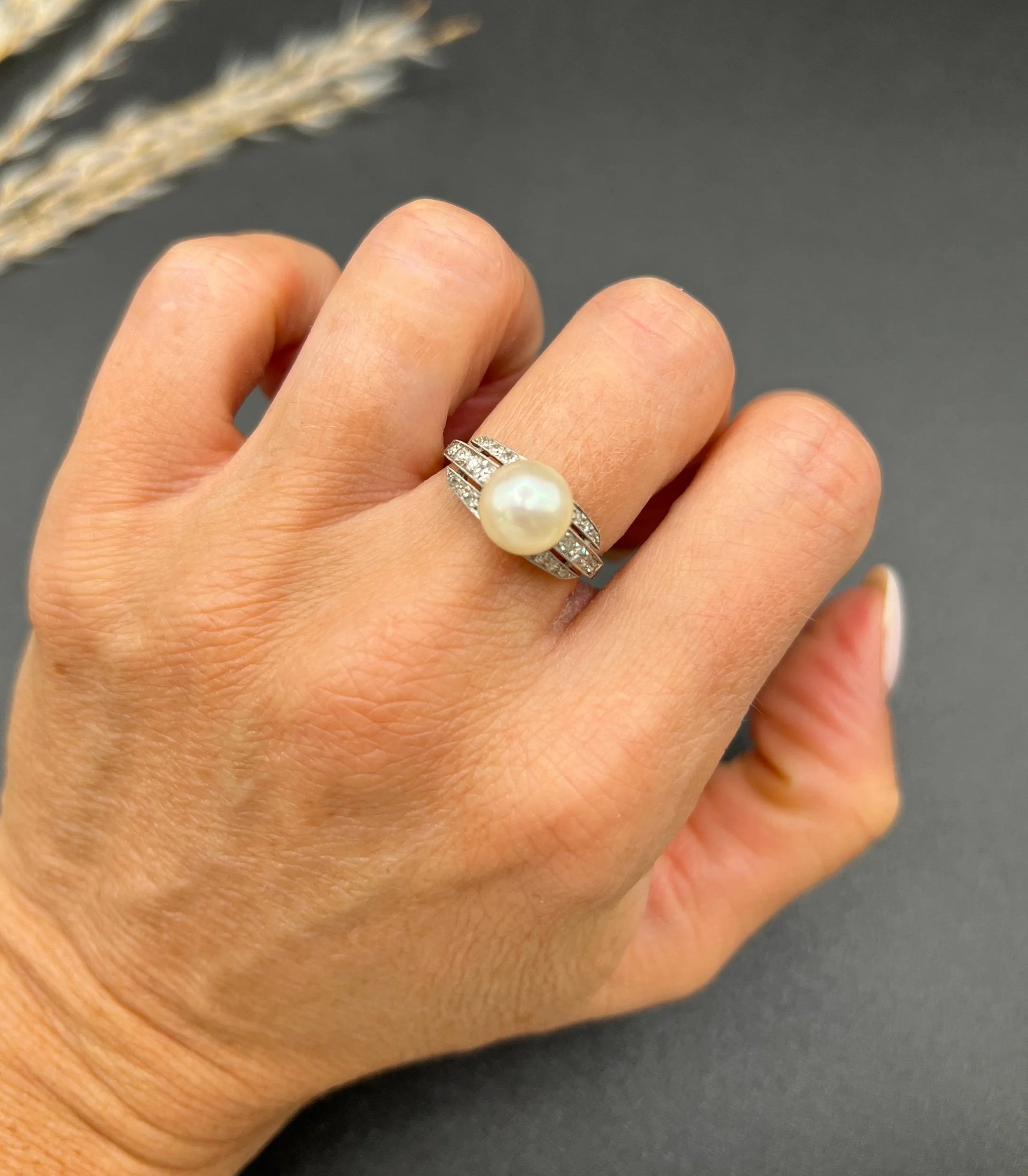 A pearl and diamond ring in platinum, modelled on a hand