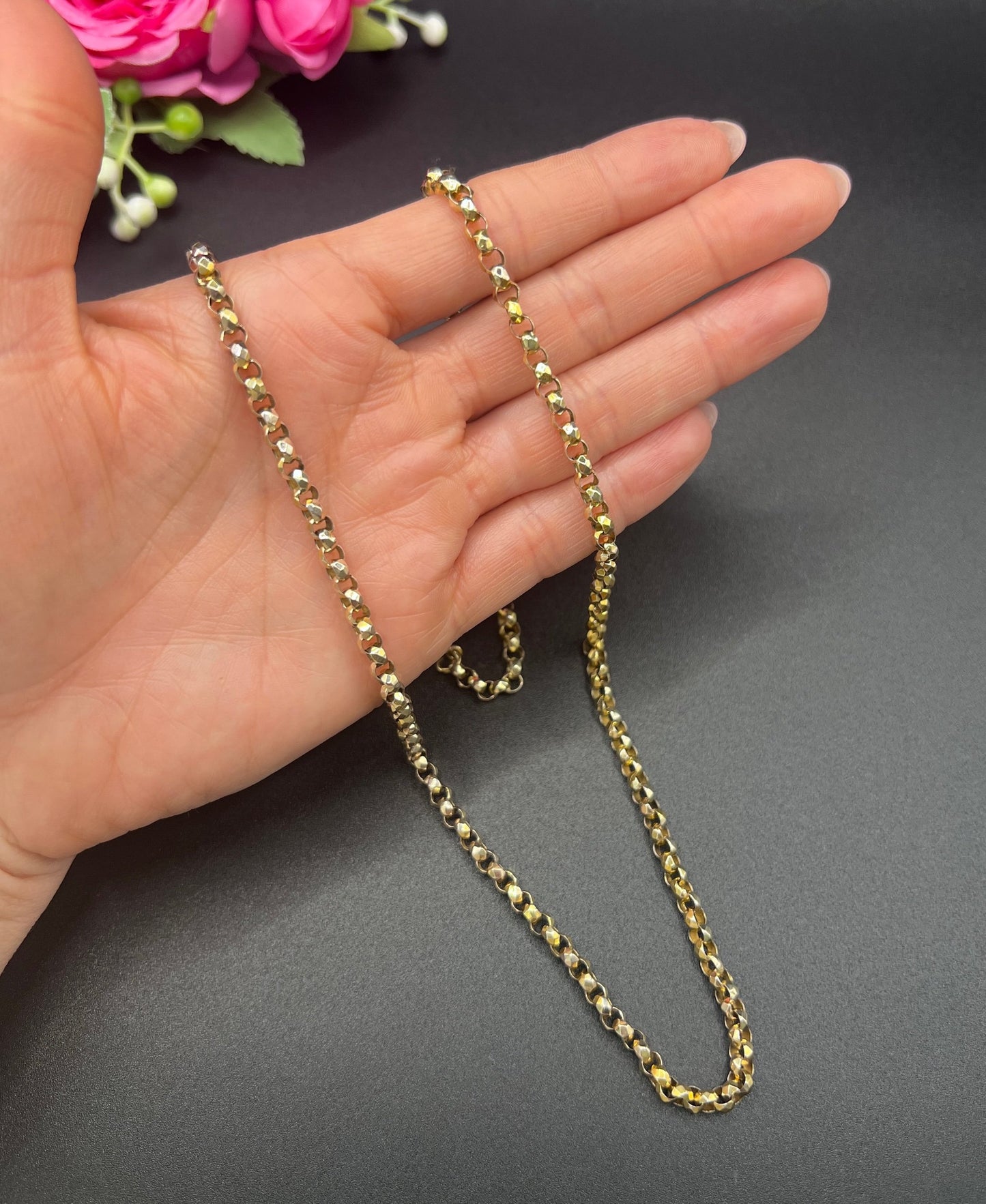 A yellow gold belcher link chain necklace, held in a hand