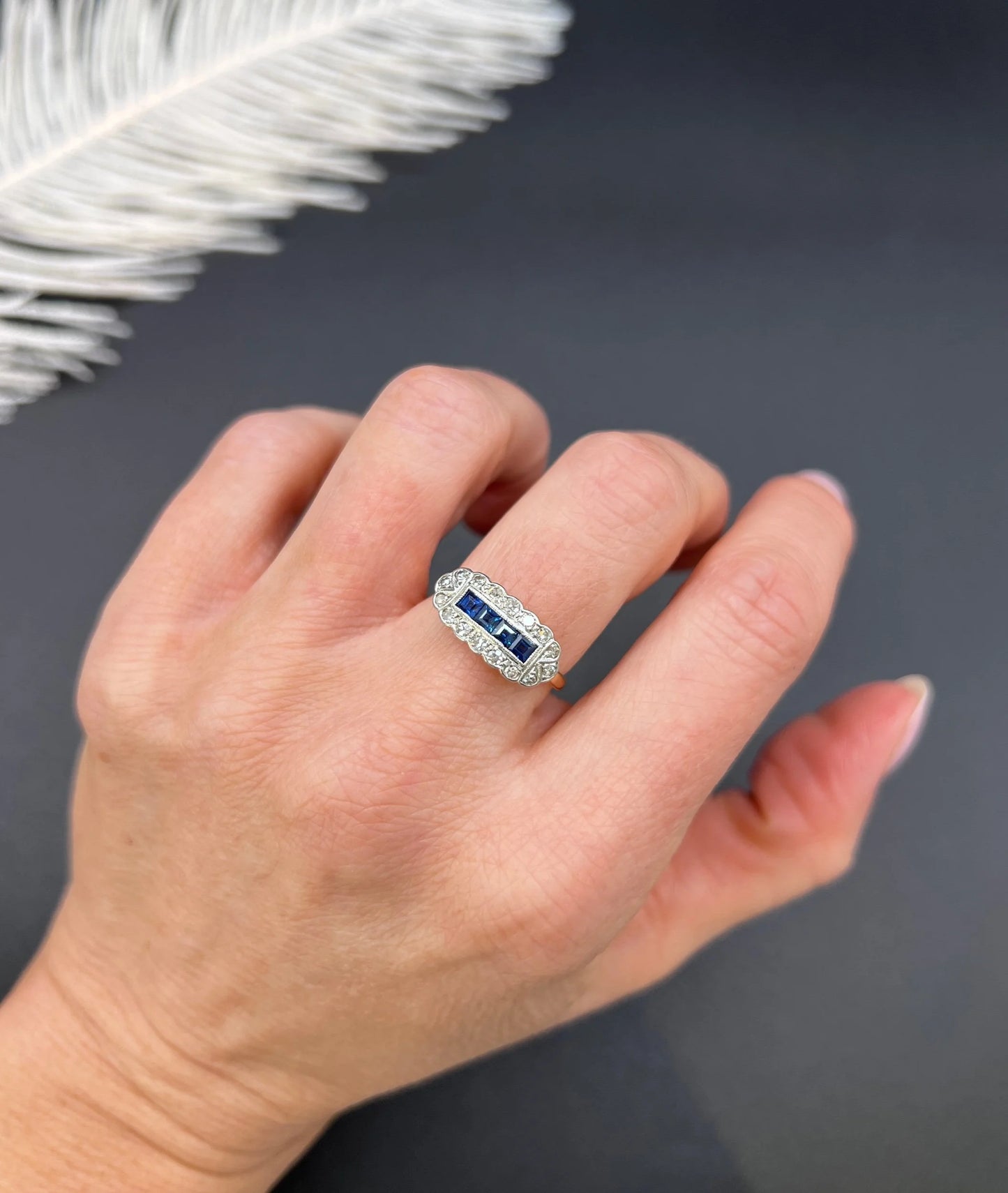A sapphire and diamond elongated cluster ring in platinum and yellow gold, modelled on a hand