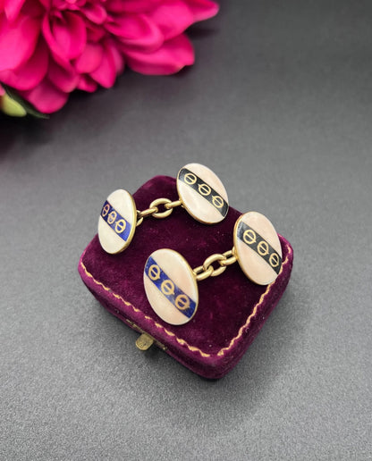 A pair of yellow gold enamel striped cufflinks with chain link fittings, on an antique box