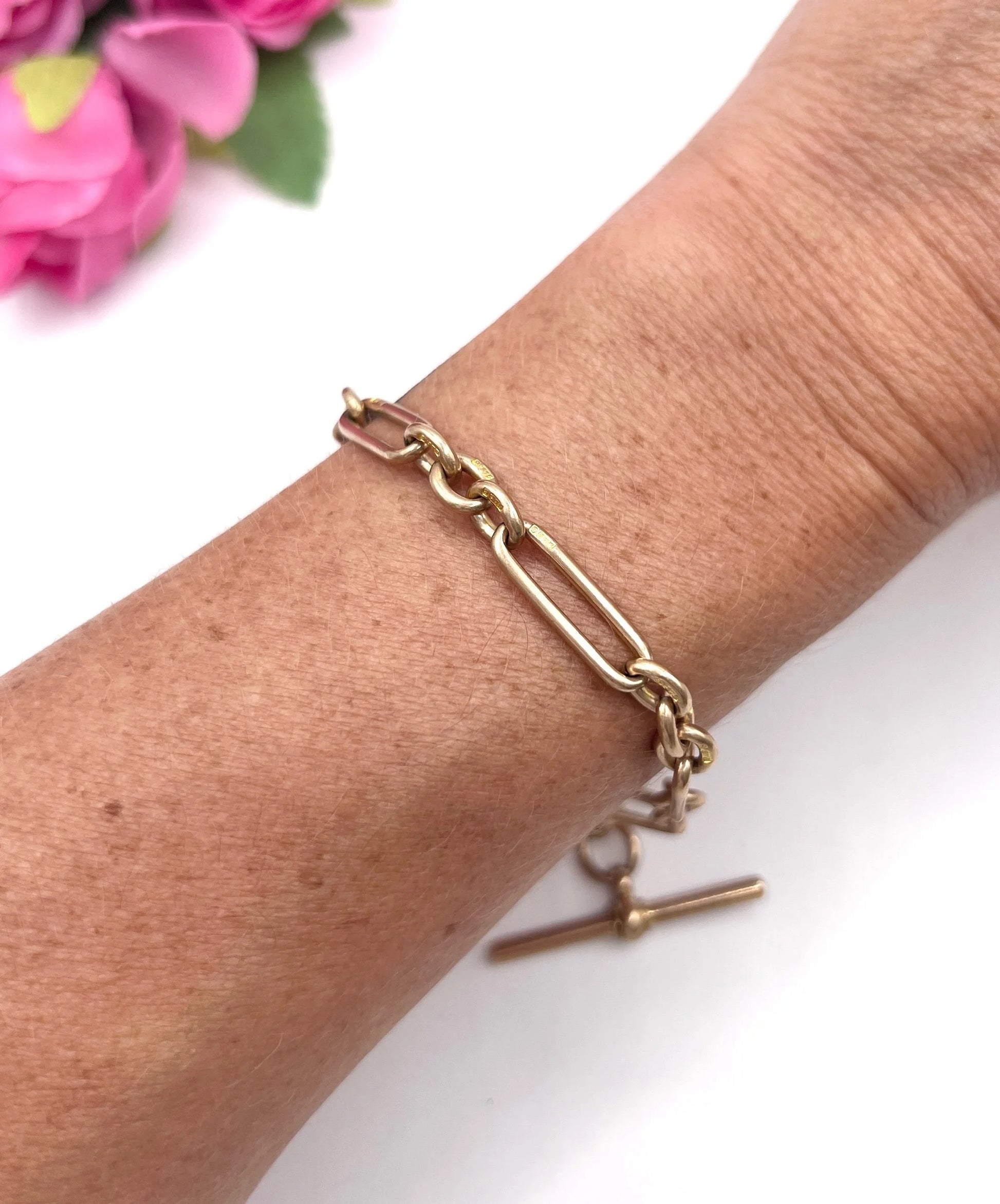 A rose gold link bracelet with a T-bar, modelled on a wrist