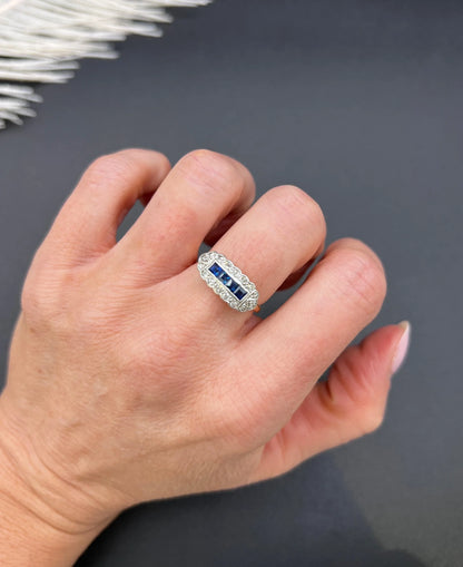 A sapphire and diamond elongated cluster ring in platinum and yellow gold, modelled on a hand