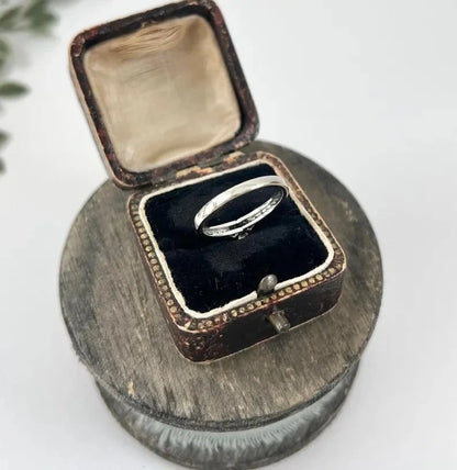 A white gold brilliant cut diamond engagement ring with diamond set shoulders, in a ring box