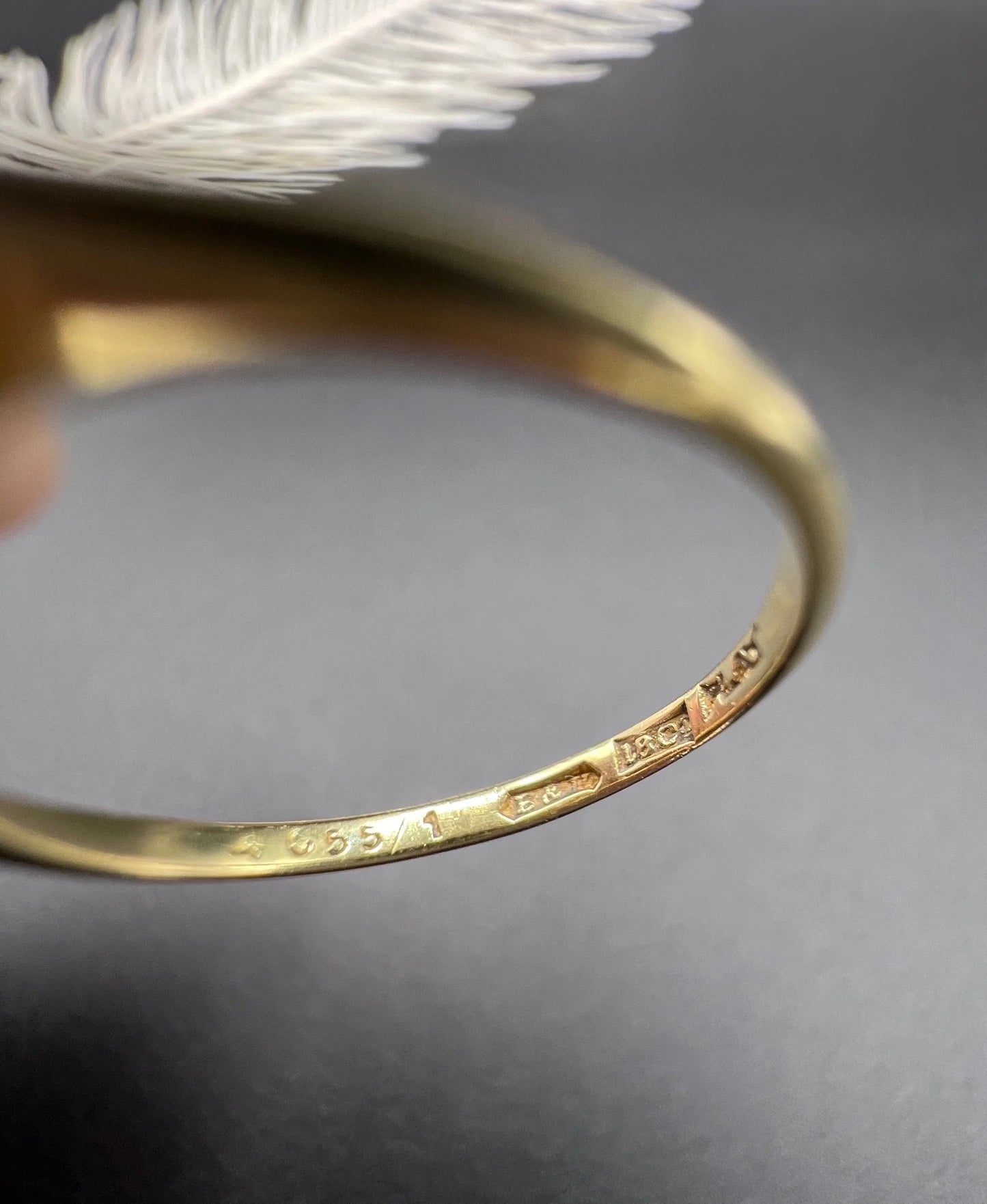 Close-up of 18CT PLAT stamps inside a yellow gold ring shank