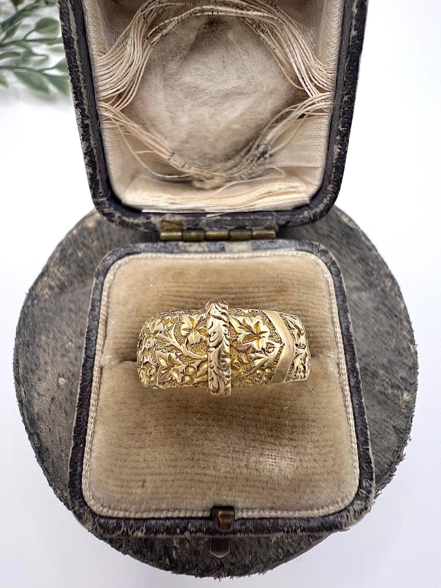 A yellow gold ornate engraved buckle band ring, in an antique ring box