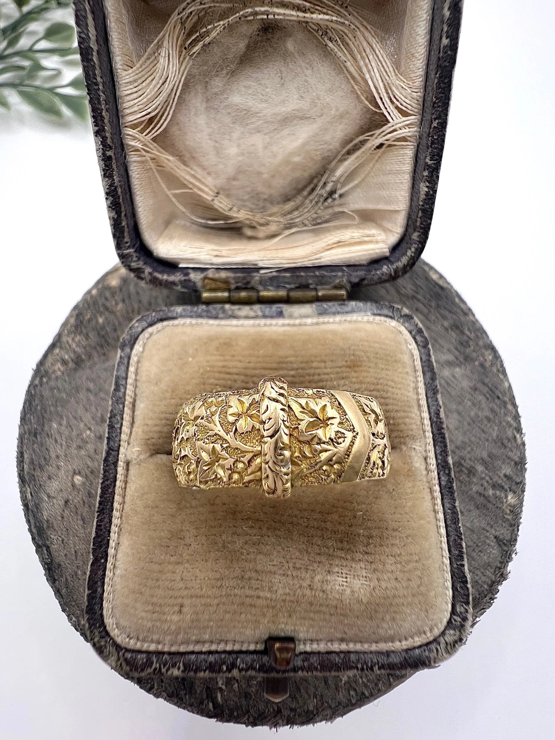 A yellow gold ornate engraved buckle band ring, in an antique ring box
