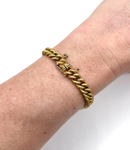 A sapphire and diamond fancy curb link bracelet in yellow gold, modelled on a wrist