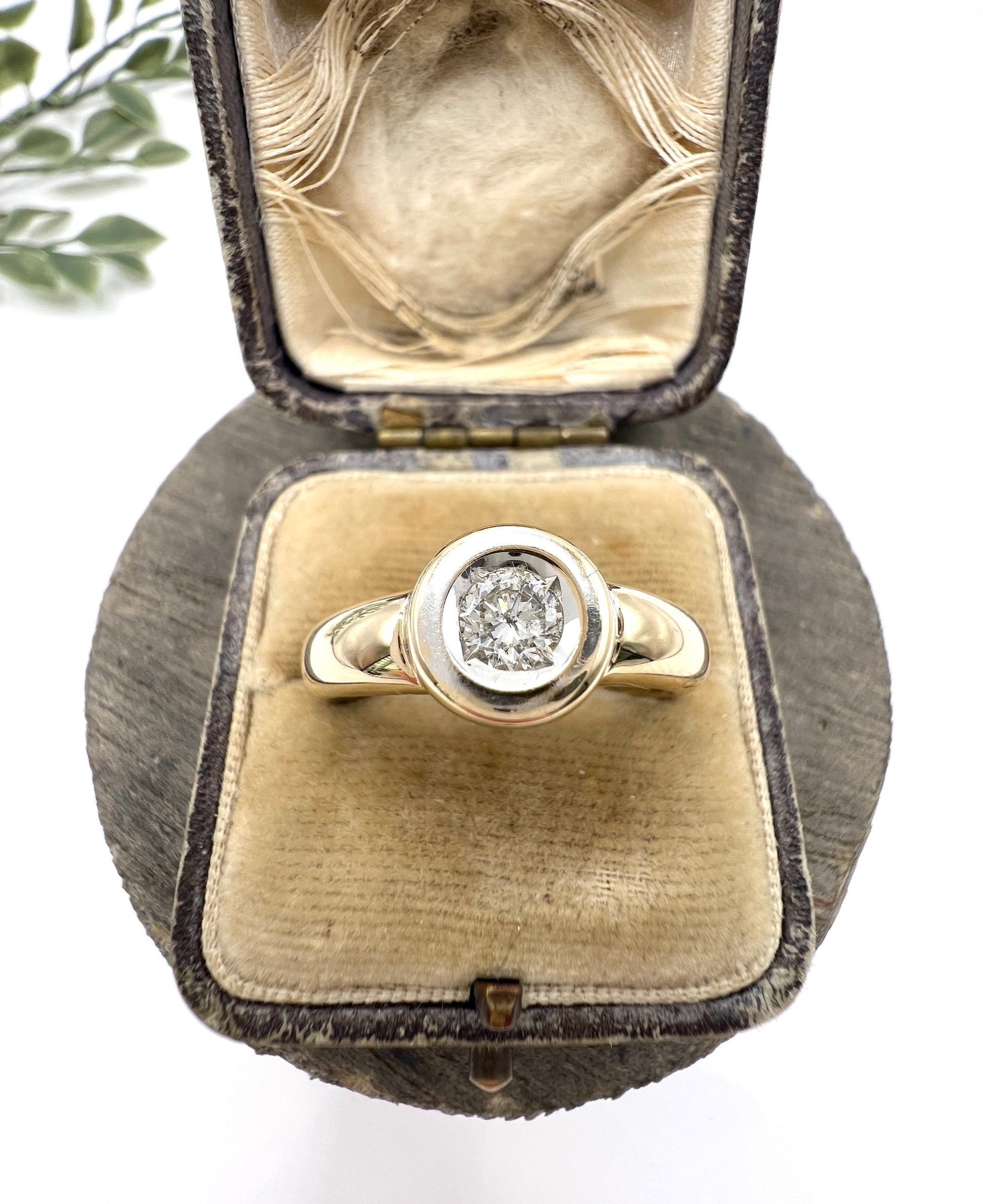 A single stone brilliant cut diamond ring bezel set in yellow gold, in a ring box