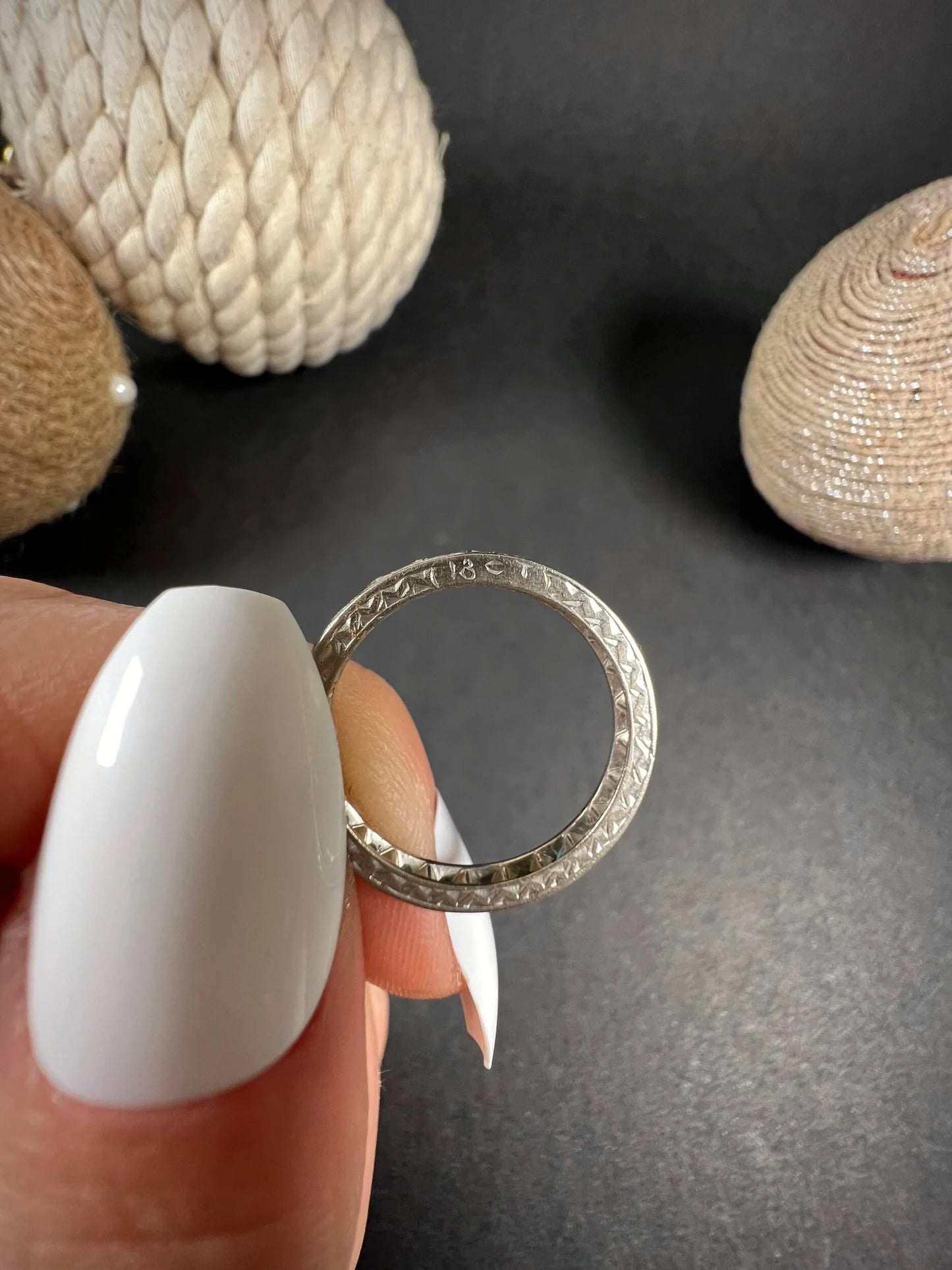 A full eternity ring in white gold, set with diamonds, held in a hand