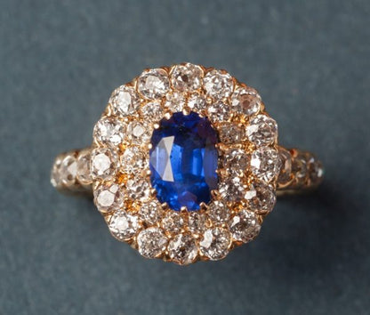 Antique Edwardian Oval sapphire and Old Cut Diamond Cluster Ring; oval faceted 1.5ct natural blue sapphire surrounded by 2.5cts old cut diamonds. Circa 1910