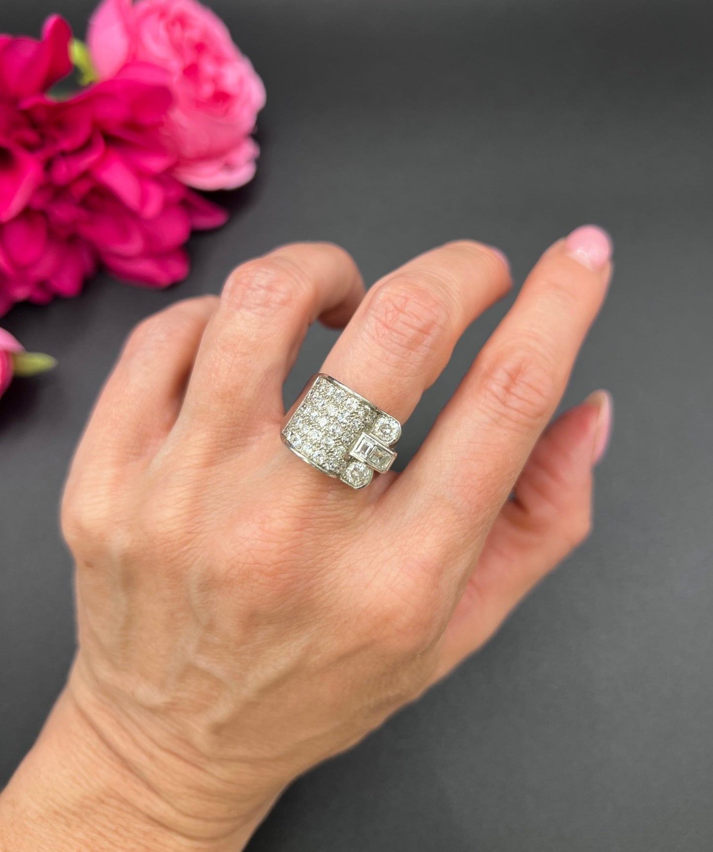 A round diamond tank style cocktail ring in platinum, modelled on a hand