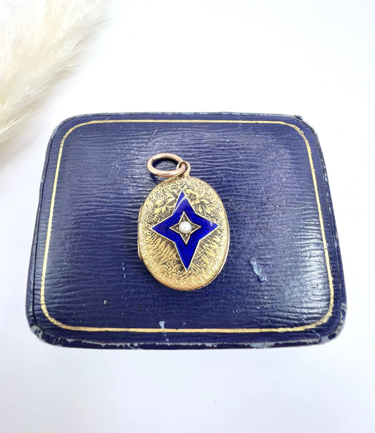 An oval yellow gold locket with a blue enamel star and seed pearl centre