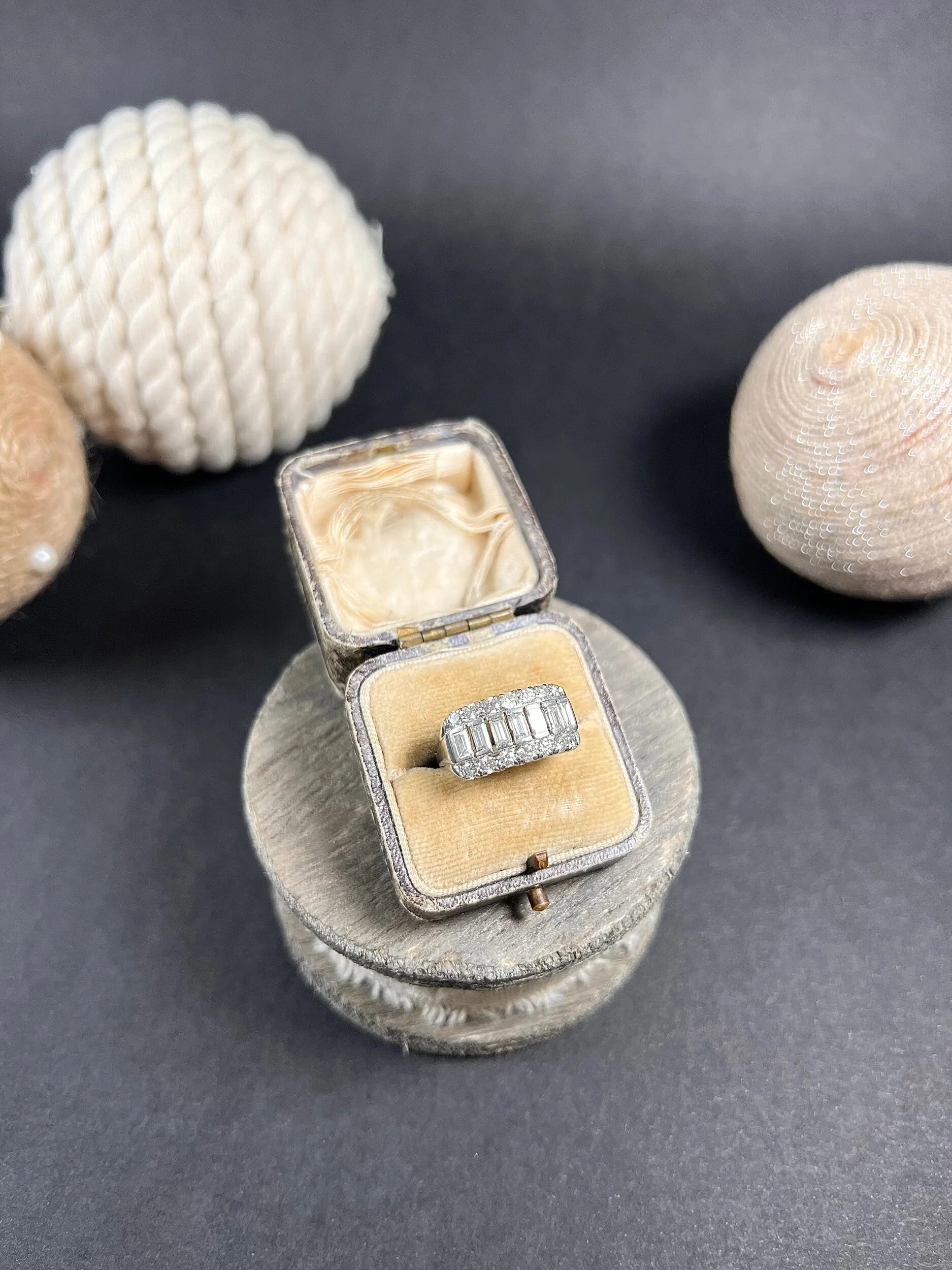 A three row diamond band ring in platinum in an antique ring box