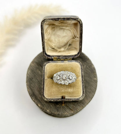 A diamond triple cluster ring in yellow and white gold, in a ring box