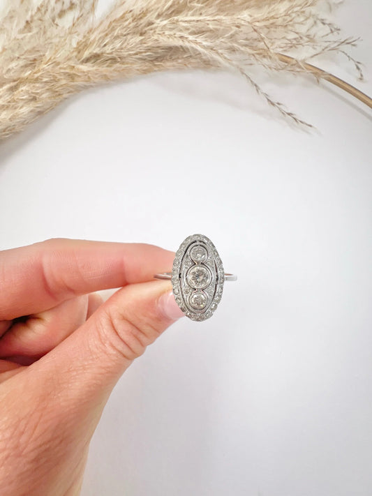 Antique 18 Carat White Gold Three Stone Diamond Oval Halo Ring, Circa 1910