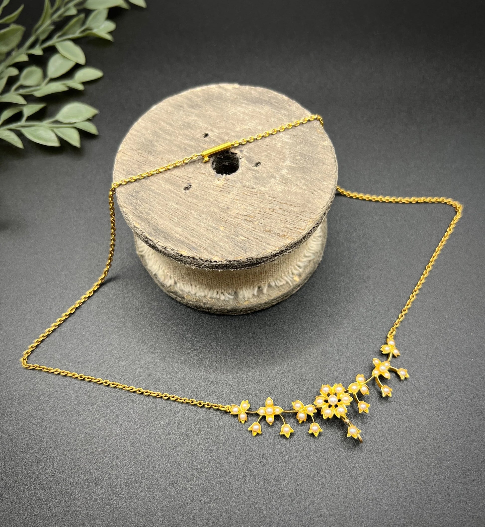 A yellow gold floral pendant necklace with seed pearls