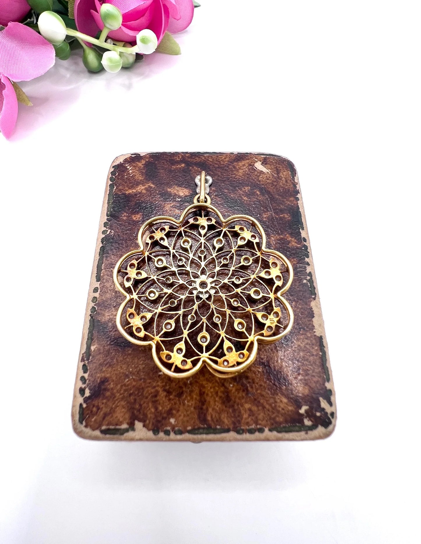 A floral openwork diamond pendant in gold and platinum