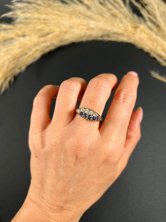 A sapphire and diamond two row boat shaped ring in yellow gold, modelled on a hand