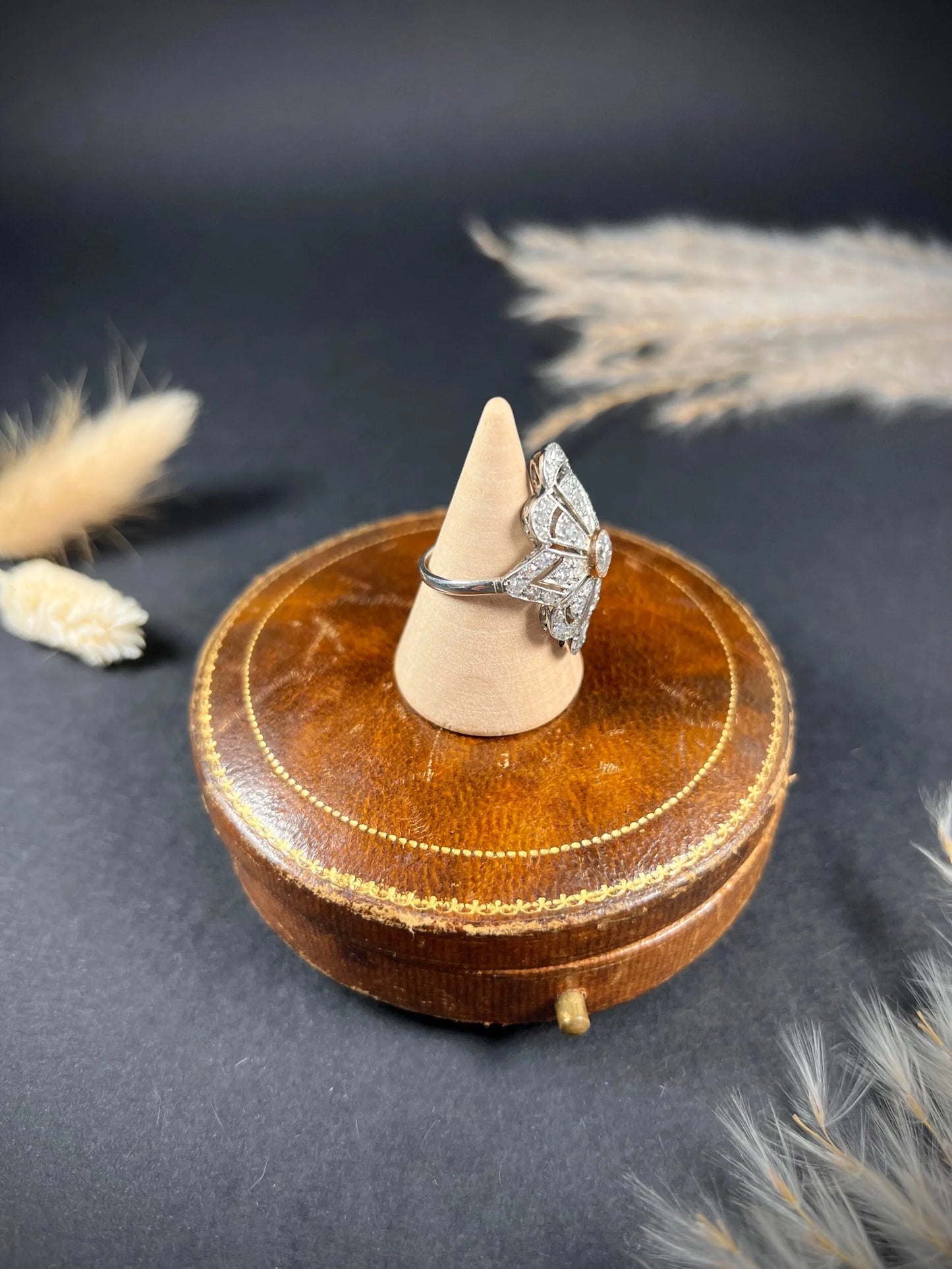 A diamond cocktail ring in white metal, on a ring cone