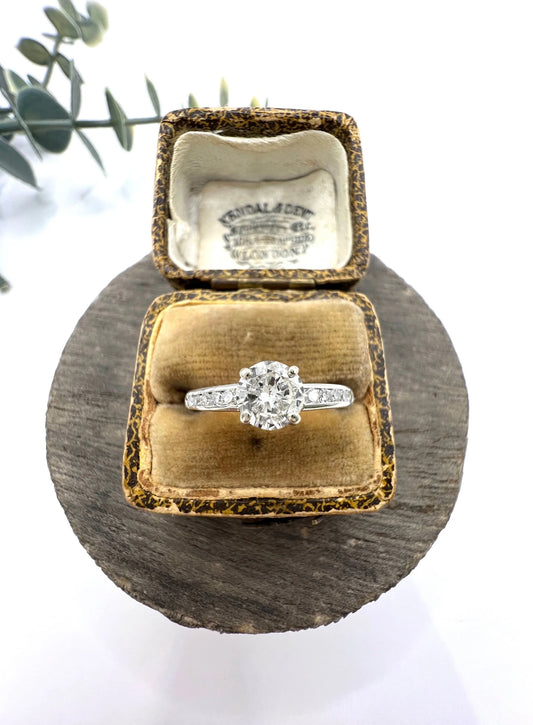 A solitaire diamond ring with diamond shoulders in platinum, in an antique ring box