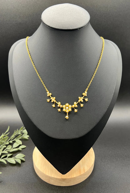 A yellow gold floral pendant necklace with seed pearls