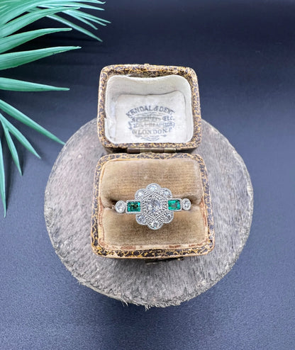 An emerald and diamond floral cluster ring in yellow gold and platinum, in an antique ring box