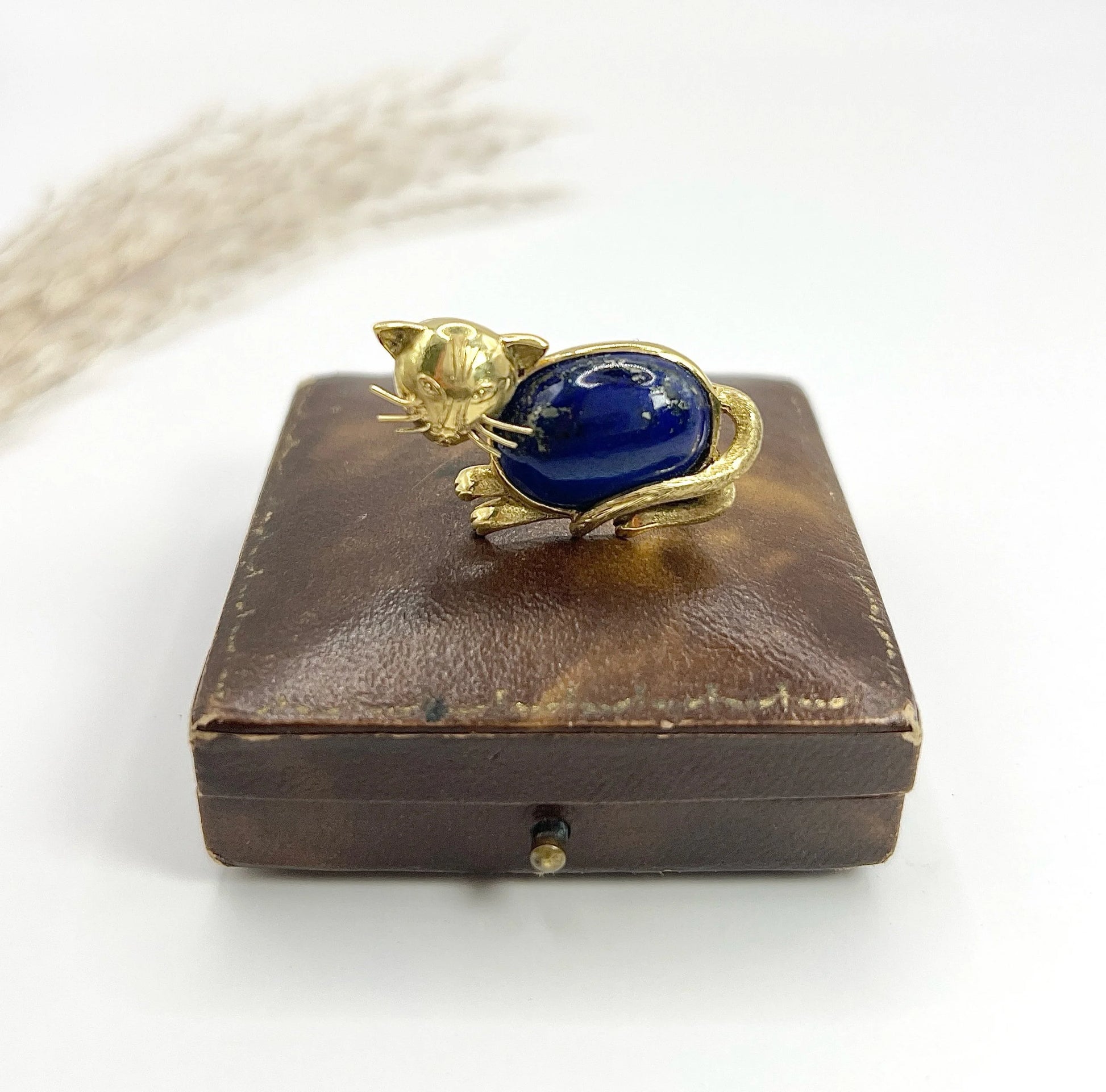 A yellow gold cat brooch with a lapis lazuli body
